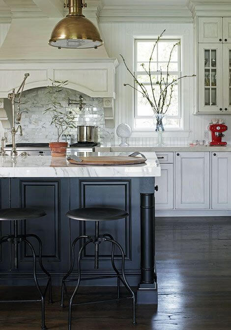 Mixed metals in the kitchen with black and white cabinets.