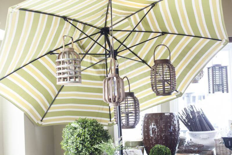 Get your patio ready for spring: Teak lanterns hang from the umbrella to illuminate your table at night.