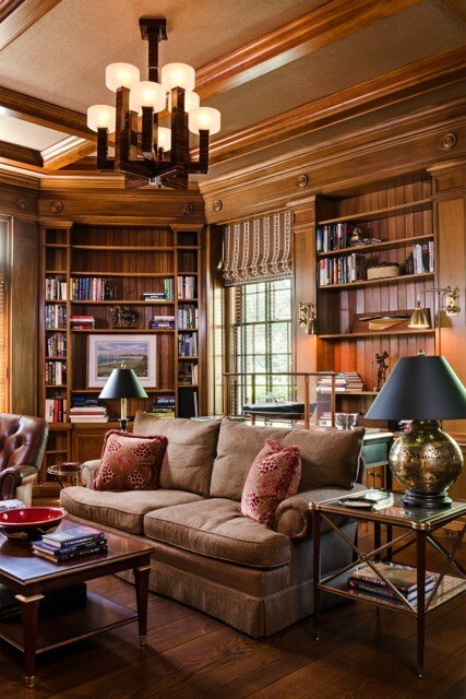 Rich walnut paneling distinguishes the library. Jamieson added Phillip Jeffries wallpaper on the ceiling between the coffers for effect.
