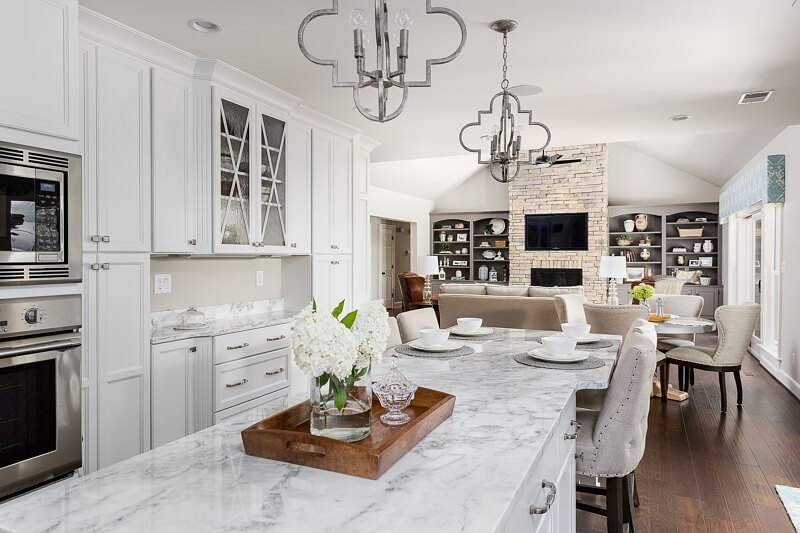 This serene and stately kitchen flows into a more casual living space that beckons you to relax by the fire.