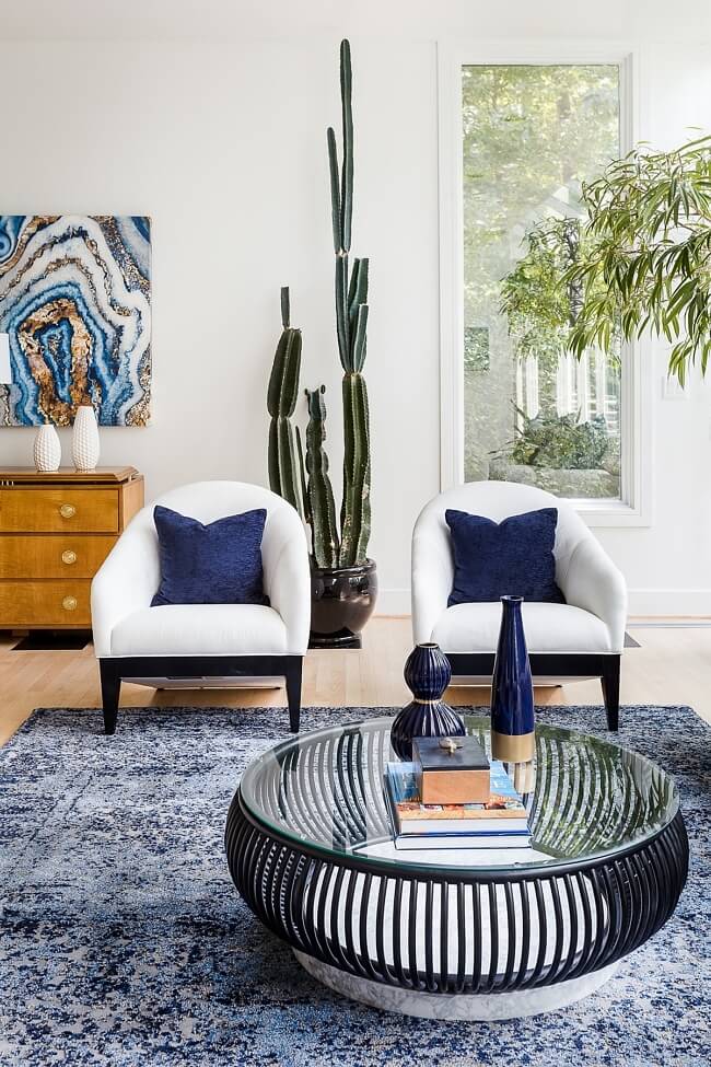Jewel-toned blue provides the color punch in this space, while echoes of nature are woven throughout in a sculptural cactus and a geode-esque work of art.
