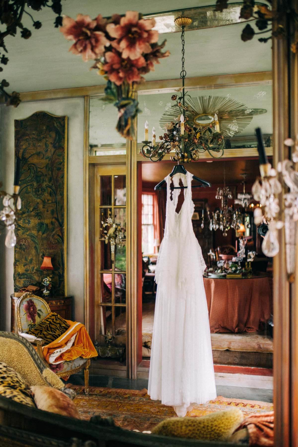 Robe de mariée suspendue dans la chambre avec des antiquités éclectiques